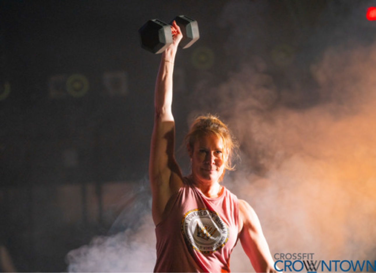 Athlete pressing a dumbbell overhead at CrossFit CrownTown